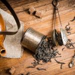 teapot surrounded with black tea leaves