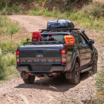 Back view of Ford Ranger with roof racks and load on them in nature