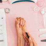 woman doing her nails at home with nail tools