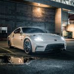 a white nissan with full body kit parked at a parking lot