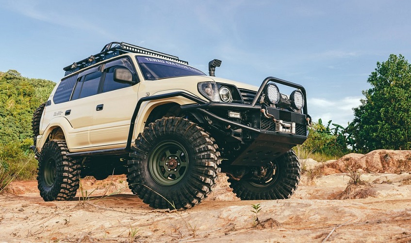 White off road Toyota Prado parked in nature