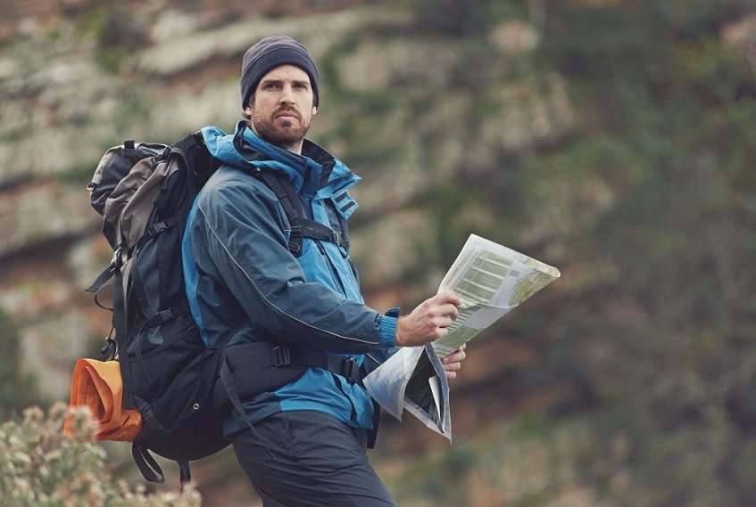 Man holding survival guide in nature