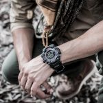 man's hands with military watch on one hand