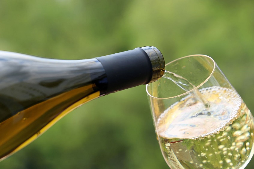 close up of person pouring chardonnay wine