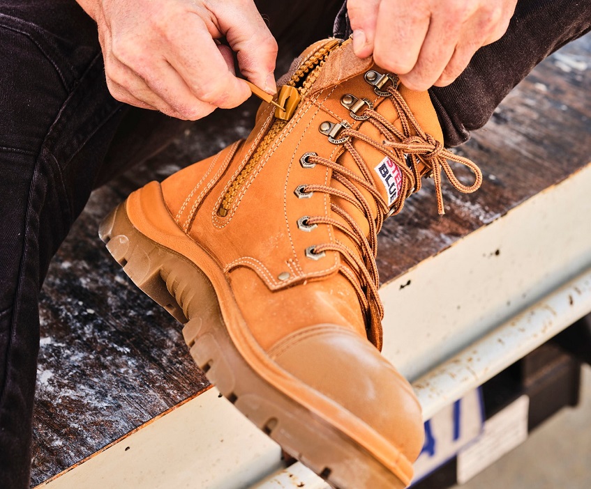 man zipping his Steel Blue safety boots